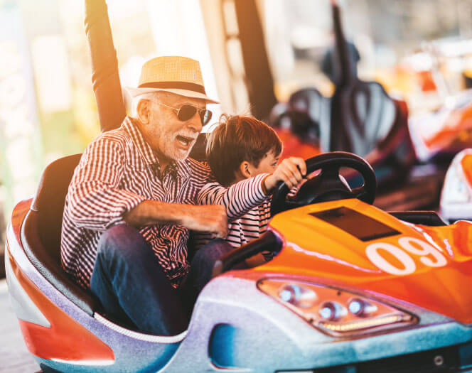 grandpa riding a bumper car with his grandson