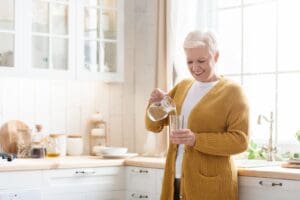 Senior woman pouring a glass of water