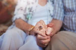 couple in assisted living holding hands