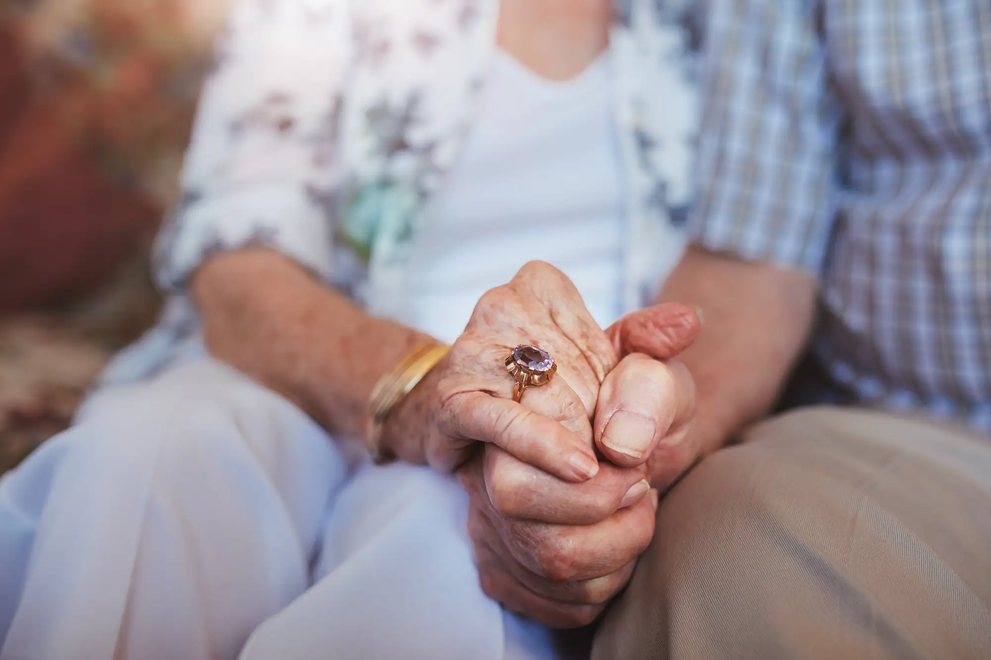 couple in assisted living holding hands