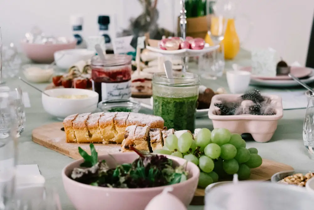 an array of breakfast foods including fruit, jam, pastries, and orange juice