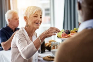 older woman eating fruit off a plate