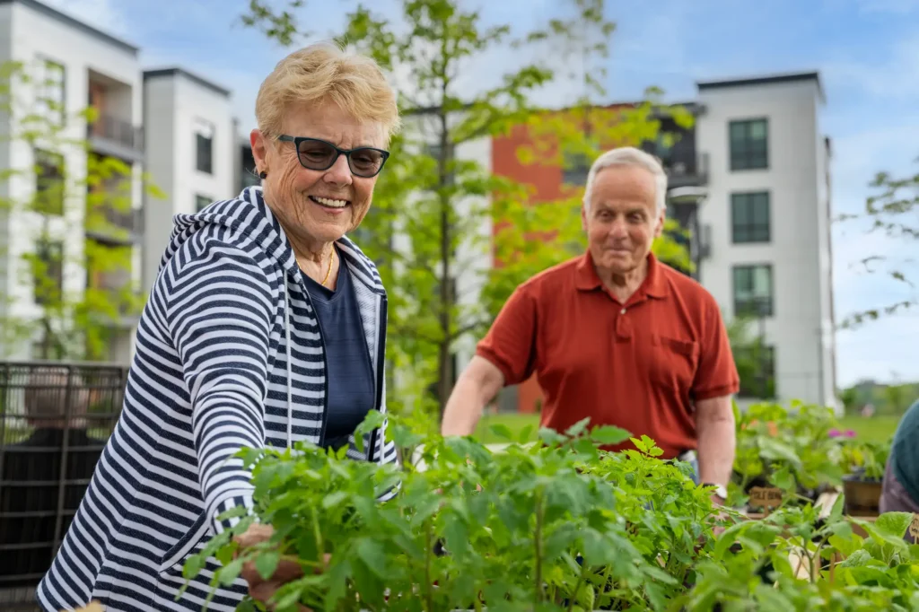 senior woman and senior man gardening while discussing the signs it's time for independent living at The Delaney at The Vale in Woburn, MA
