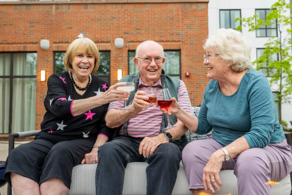 Seniors at toasting their drinks after recognizing the signs it's time for independent living and joining The Delaney at The Vale in Woburn, MA.