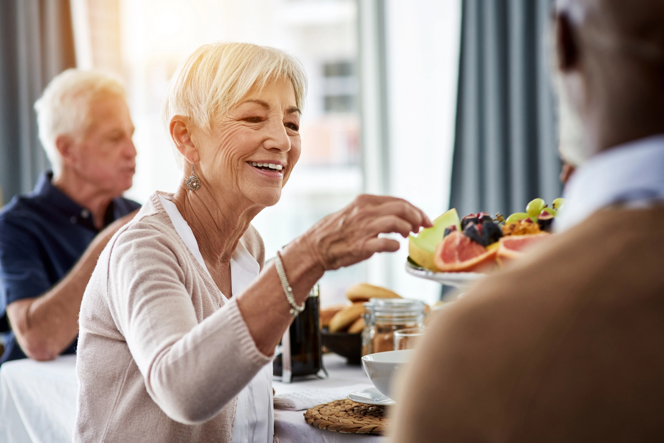 3 elderly adults enjoying healthy meals for seniors at The Delaney at The Vale in Woburn, MA.