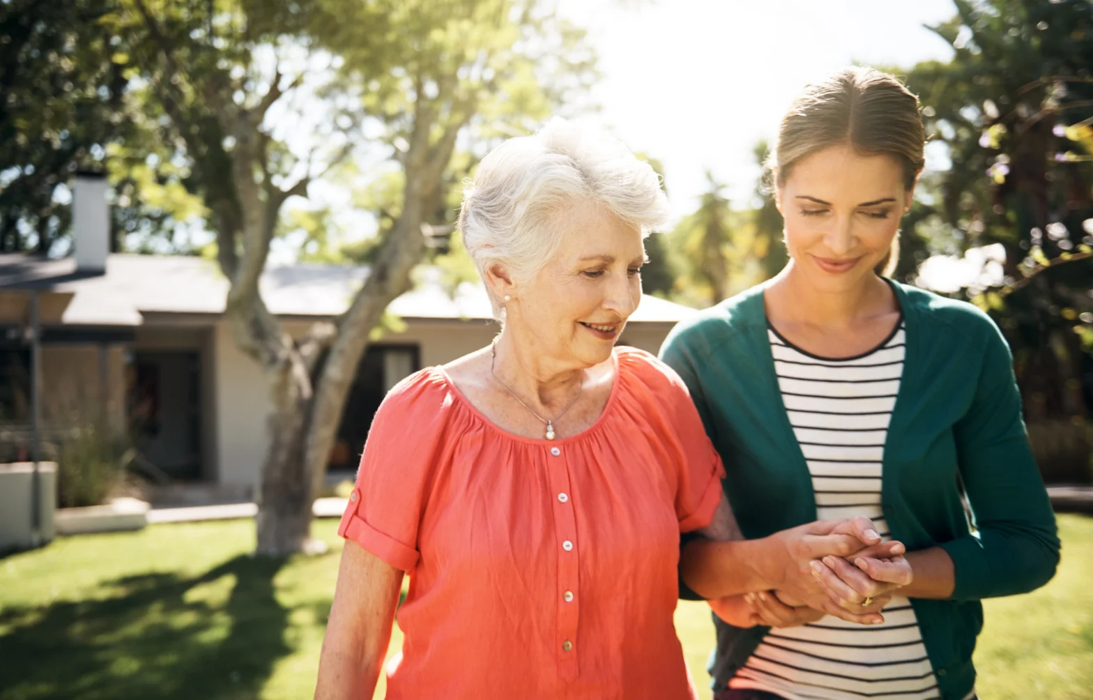 adult daughter helping senior mother walk and decide when to move from assisted living to memory care
