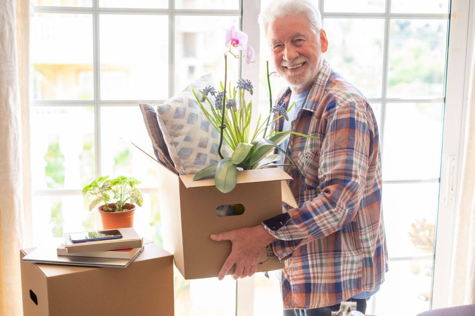 An elderly man from the Boston Area packing & preparing to move to senior living early at The Delaney at The Vale.