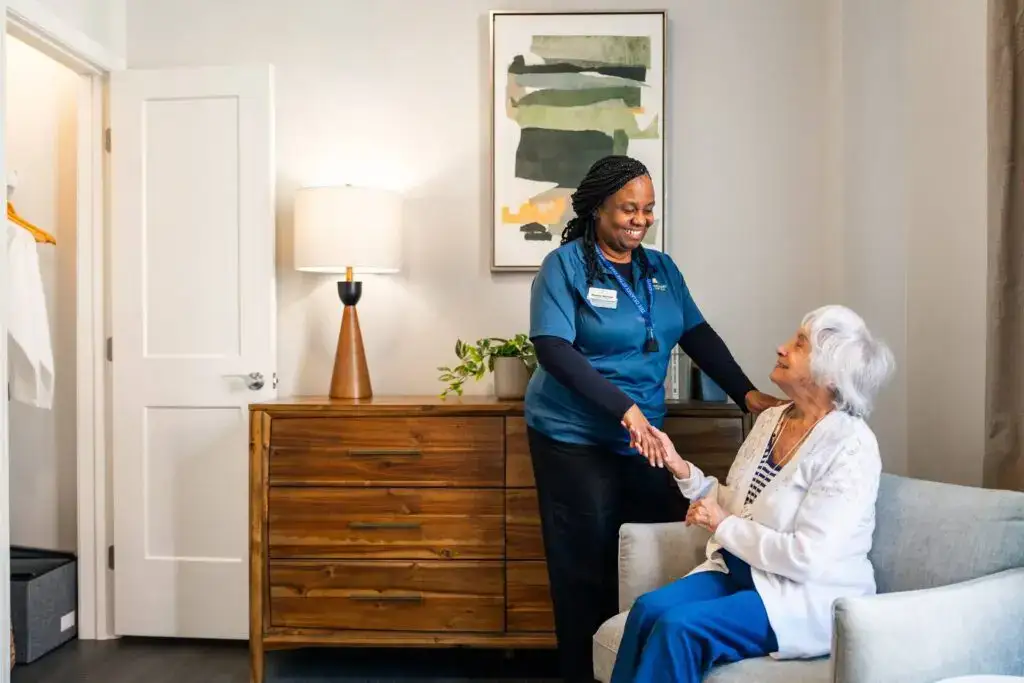 A caregiver from The Delaney at The Vale providing daily support to a resident in assisted living in Woburn, MA.